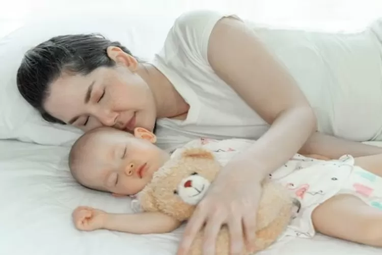 Ibu yang menidurkan anak bayinya (freepik)