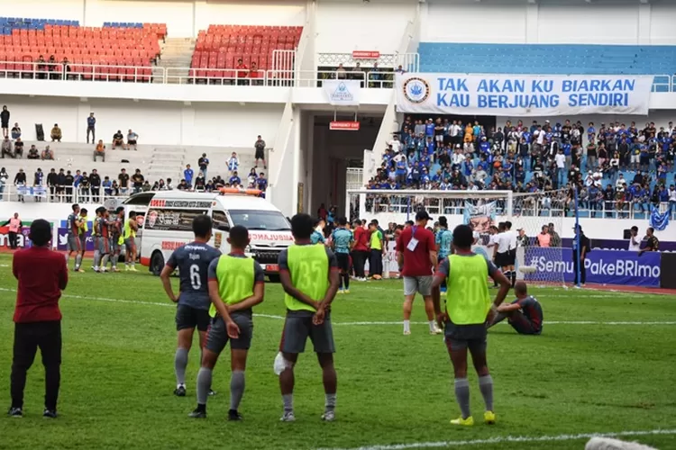 Para pemain Madura United saat menyaksikan rekannya, Ricki Ariansyah diberi pertolongan medis karena mengalami kolaps di lapangan.  (Ayosemarang.com/ Audrian Firhannusa)