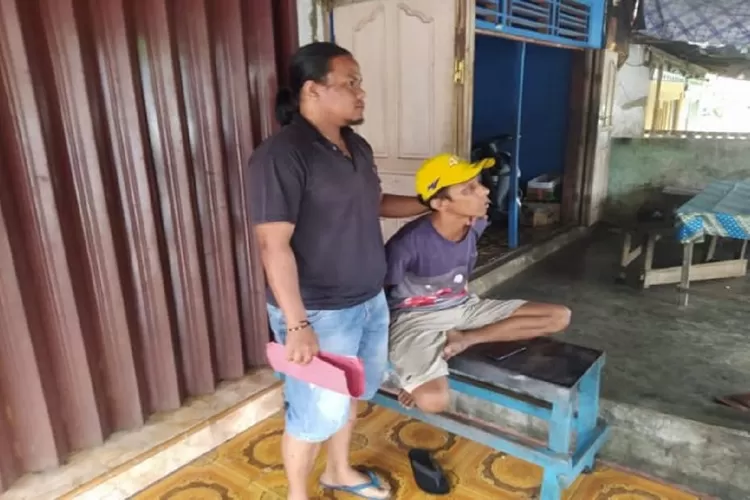Uncu (topi kuning) saat diinterogasi polisi di kediamannya di Kecamatan Lubuk Basuk, Kabupaten Agam.