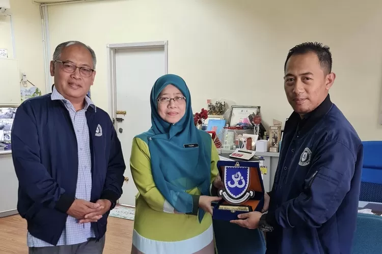 Ketua Yayasan Prima Cendekia Islam Prof Dadan Wildan didampingi Kepala SMP PCI Beny Saputro M.Pd memberikan plakat kepada Penolong Kanan Tadbir dan Kurikulum Sekolah St. Mary Puan Faizah Bt. Mohd Yasin - Foto: Dokumen PCI