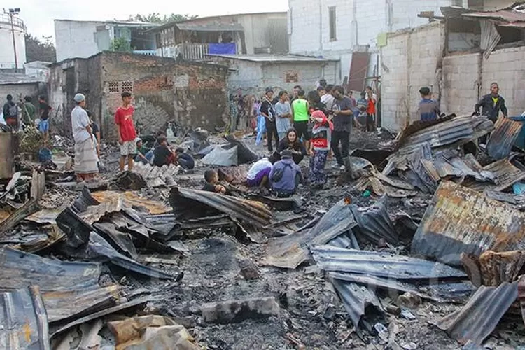 Puing  sisa rumah  warga korban kebekaran Depo Plumpang dibersihkan oleh pasukan orange, Munggu (19/3/2023).