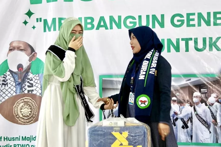 Wisudawati tahfizh Al Quran 30 juz PTWQ, Rahdini Herdiyanti Puteri tak henti-hentinya menahan tangis ketika menerima koper umroh dari Komisaris Tanur Muthmainnah Tour Fitri Heni - Foto: Henry Lukmanul Hakim