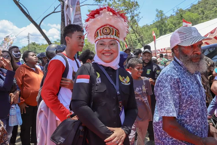 Menaker Ida Fauxiyah mengenakan hiasan kepala ala Papua. 