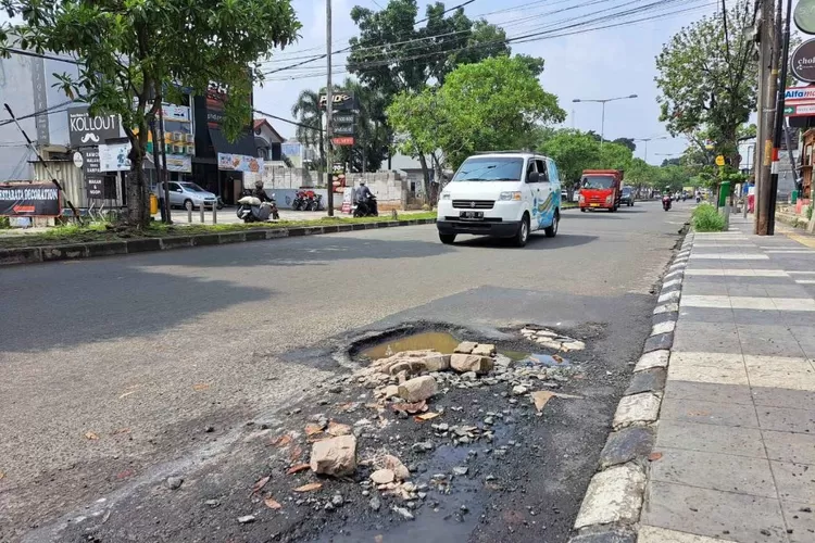 Kondisi Jalan Achmad Adnawijaya, Kecamatan Bogor Utara, Kota Bogor, yang berlubang cukup berbahaya bagi pengendara.