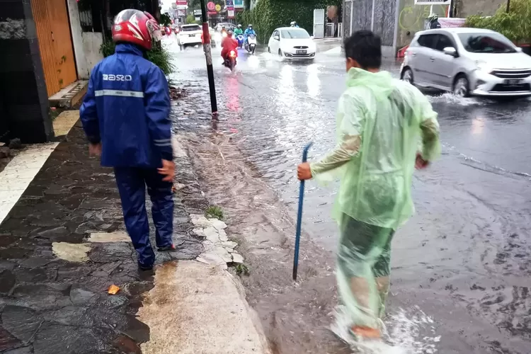 BANJIR : Satgas DPUPR Kota Depok melakukan penanganan banjir di Jalan Siliwangi Kelurahan Depok, Minggu (26/3).  (ISTIMEWA)