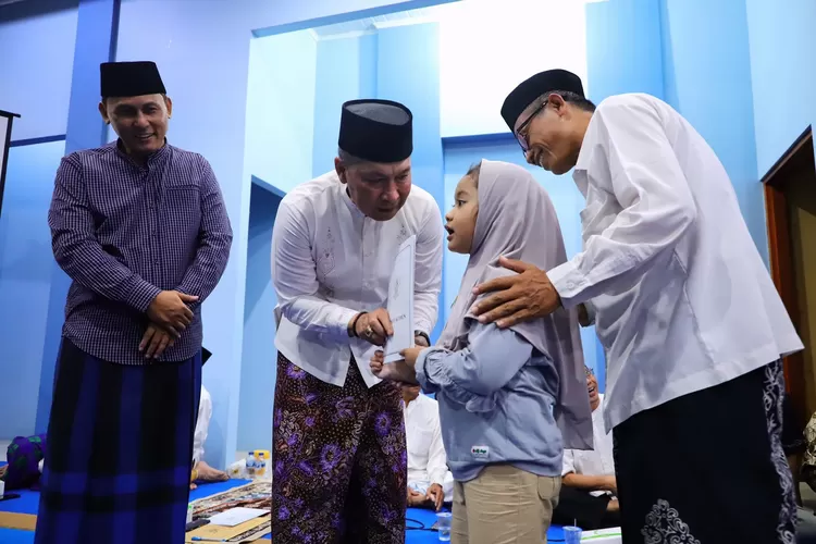 Bupati Kudus Hartopo menyerahkan bantuan secara simbolis kepada salah satu anak yatim piatu usai pelaksanaan tarhima di Masjid Baitul Haq Desa Singocandi Kecamatan Kota Kudus. (Foto: Diskominfo Kudus)