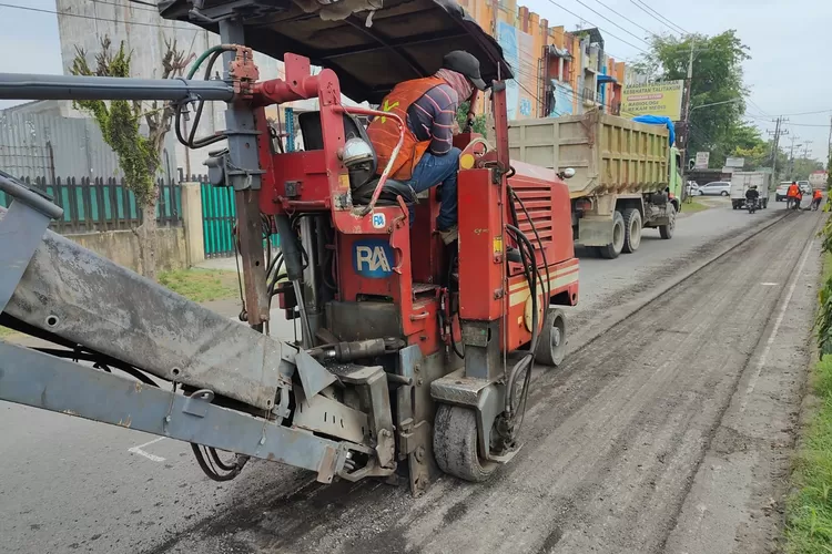 Petugas sedang mengoperasikan alat berat saat melakukan perbaikan jalan provisi. (Realitasonline.id/Kominfo Medan)