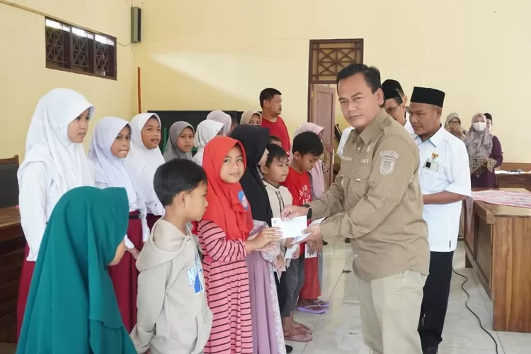 Camat Bandar saat menyerahkan santunan kepada fakir miskin dan anak yatim piatu, antuan dari UPZ dan Baznas. (Muslihun Kontributor Batang)