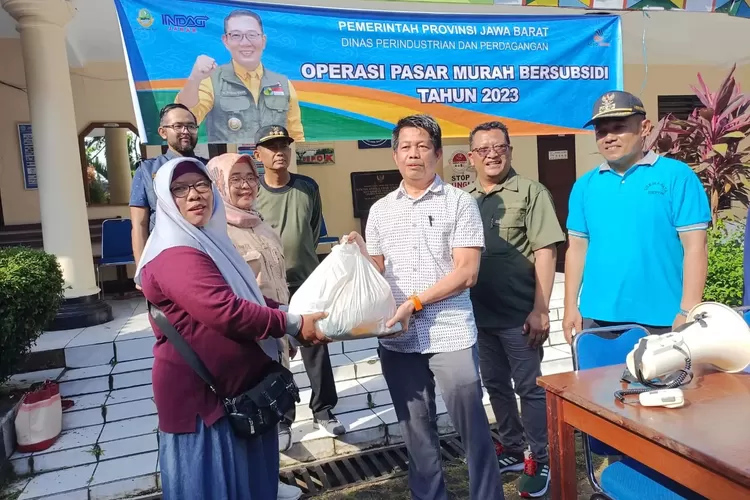 Kepala Dinas Perdagangan dan Perindustrian Kota Depok, Zamrowi memberikan paket sembako bersubsidi dari Pemerintah Provinsi Jawa Barat ke masyarakat pra sejahtera di Kelurahan Sukmajaya, Minggu (9/4).