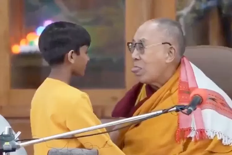 A screenshot taken from a video of the Dalai Lama asking a boy to suck his tongue.