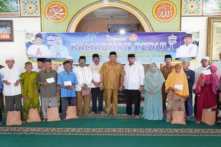 Syah Afandin Foto bersama usai penyerahan bantuan ke kaum dhuafa (Realitasonline/AA)