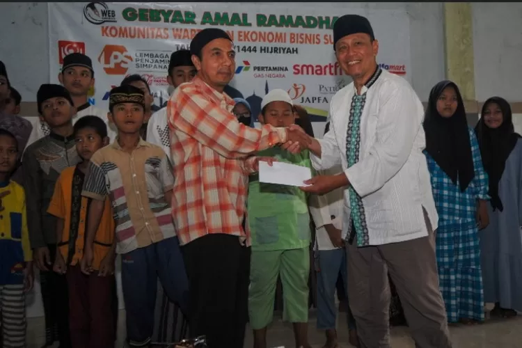 Ketua Pelaksana &ldquo;Gebyar Amal Ramadan Komunitas Wartawan Ekonomi Bisnis Surabaya 1444 Hijriyah&rdquo; Harry Prasodjo (kanan) saat menyerahkan santunan