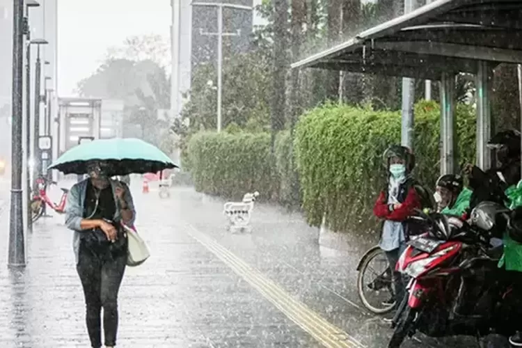 Ilustrasi orang melintas di tengah hujan di Jakarta.  (Dok.JawaPos.com)