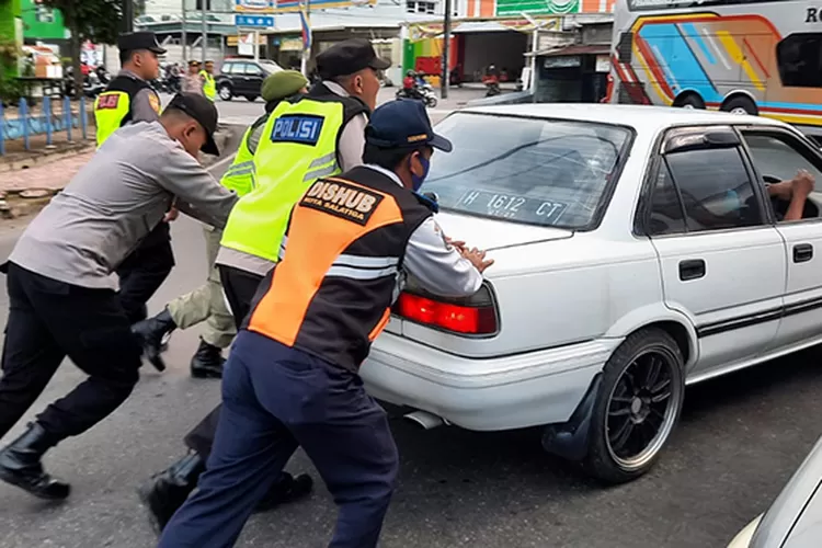 Petugas mendorong mobil yang mogok di Tingkir Salatiga saat arus mudik Lebaran.  (Dok Humas Polres Salatiga )