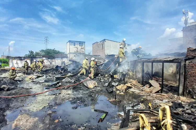 Petugas pemadam kebakaran sedang memadamkan gudang rosok dan 3 rumah yang terbakar di Gayamsari Semarang. (Ayosemarang.com/ Audrian Firhannusa)