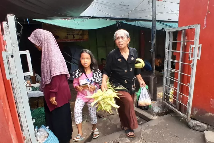 Seorang ibu dan cucu dari anaknya bersama-sama membeli ketupat untuk Lebaran Syawal di Semarang. (Ayosemarang.com/ Audrian Firhannusa)
