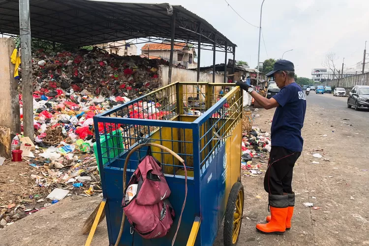 Petugas TPS (Tempat Pembuangan Sampah Sementara) yang sedang memilah-milah sampah. 
