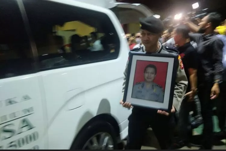 Seorang anggota polisi membawa foto AKBP Buddy. Keluarga menduga kematian Katas Narkoba Polres Jakarta Utara ada kaitannya dengan mafia narkoba.  