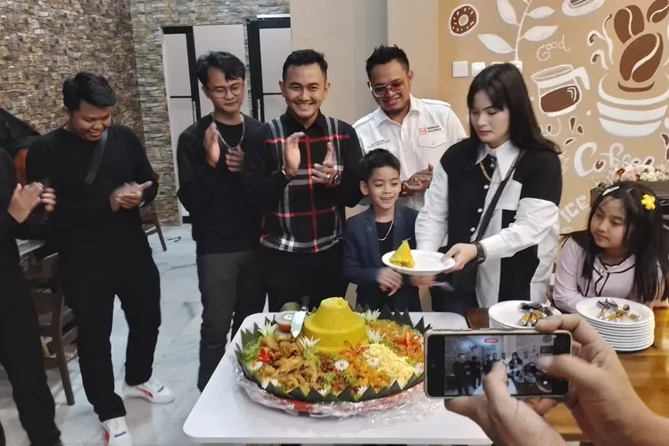 Aktris film Syahlimar Malik didampingi  suami tercinta Erick Syafutra memotong tumpeng  sebagai wujud  syukur  atas dibukanya  Madame  Eemooi di  Jalan Abdul Majid, Cipete Utara, Jakarta Utara, Senin (8/5/2023).