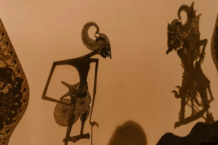 Wayang kulit Indonesia adalah seni tradisional boneka kulit yang berasal dari Indonesia. Wayang kulit dimainkan dengan menggunakan layar atau kain putih sebagai latar belakang, dan boneka kulit yang diberi warna dan dihias secara detail yang dimainkan oleh dalang atau pemain cerita. (canva.com)