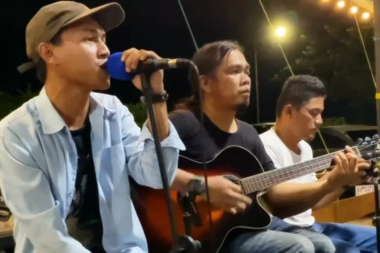 Doni Satire (Tengah) Gitaris Pengamen Band saat manggung menyanyikan album Percayalah Cinta