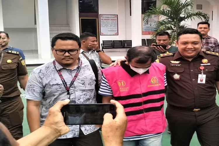 Kasipitsus Okto Silaen didampingi Kasi Intel Aguinaldo Marbun membawa pelaku menuju mobil tahanan di kantor Kejari Asahan&nbsp; (Realitasonline.id/HS)