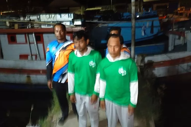 Dua ABK KM Serba Prima 8 yang selamat dari kebakaran, Nur Hasim dan Hari Setiawan (kaos hijau), tiba di Dermaga Pelabuhan Perikanan Samudra Cilacap, Jumat (19/5/2023) dini hari.  (ANTARA/HO-Satpolair Polresta Cilacap)