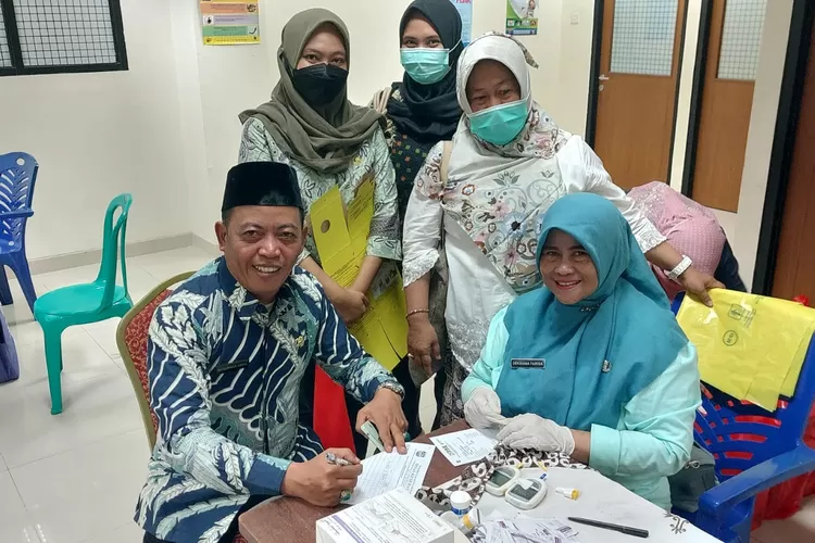 PANTAU : Kepala UPT Pasar Cisalak, Muhamad Sahal memantau skrining kesehatan bagi Staff  dan pedagang di Pasar Cisalak.