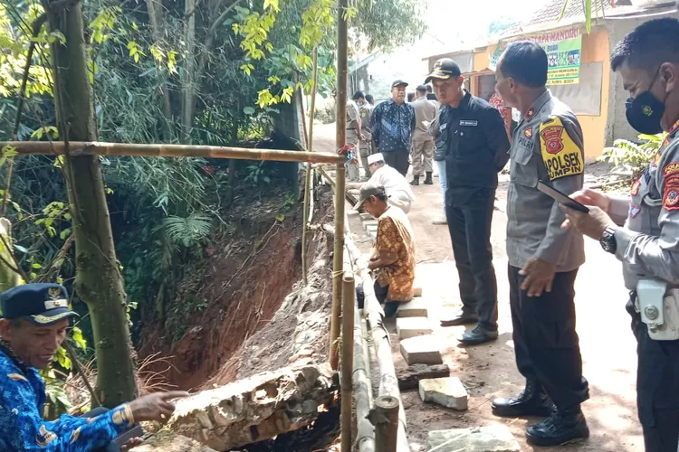 Dinding penahan tanah jalan desa di Kampung Medang, Desa Sukamulya longsor.