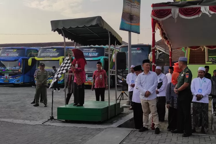 Bupati Demak Eisti'anah yang didampingi Ketua DPRD Kabupaten Demak mengibaskan bendera pelepasan calon haji dari Gedung IPHI Demak.  (Dok Zaidie)