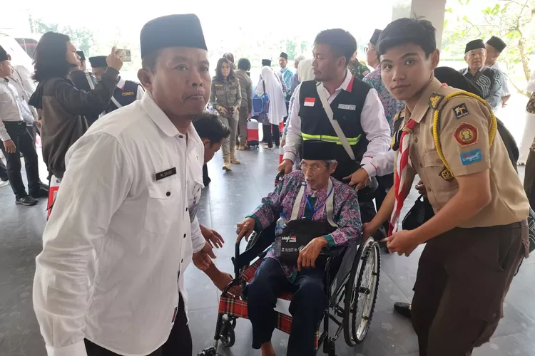 Anggota pramuka dari Saka Amal Bakti Kemenag Kabupaten Bogor membantu proses keberangkatan para calon haji yang tergabung dalam kloter 04 asal Kabupaten Bogor, Rabu (24/5/23).