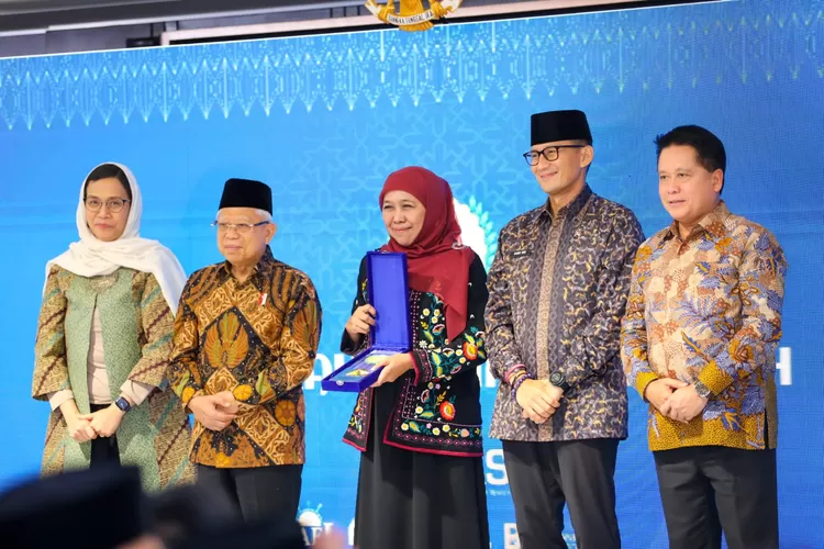 Gubernur Jawa Timur Khofifah Indar Parawansa saat menerima penghargaan dalam ajang Anugerah Adinata Syariah KNEKS.