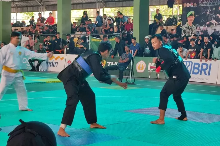 Atlet silat DKI Jakarta sabuk biru tengah bertanding menghadapi lawannya.