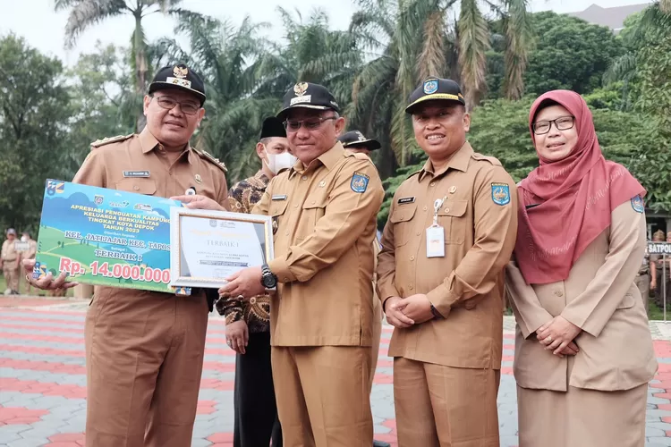SERAH TERIMA : Lurah Jatijajar, Mujahidin Menerima Penghargaan Lomba Apresiasi Kampung KB Tingkat Kota Depok Tahun 2023, di Lapangan Balai Kota Depok, pada Apel pagi, Senin (29/5). (ANDIKA EKA/RADAR DEPOK)