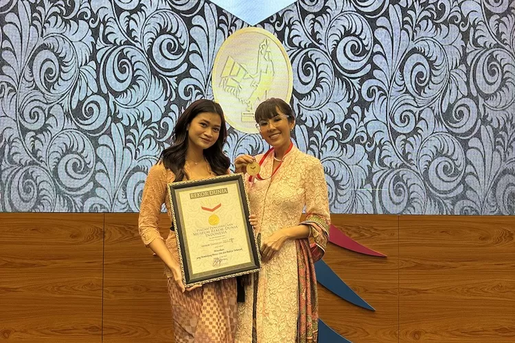 Rieka Nur Asy Syam, Program Officer Bakti Budaya Djarum Foundation dan Renitasari Adrian, Program Director Bakti Budaya Djarum Foundation (kanan) menunjukkan penghargaan dari MURI sebagai perusahaan yang terbanyak mendukung pentas seni dan budaya.  (Istimewa)