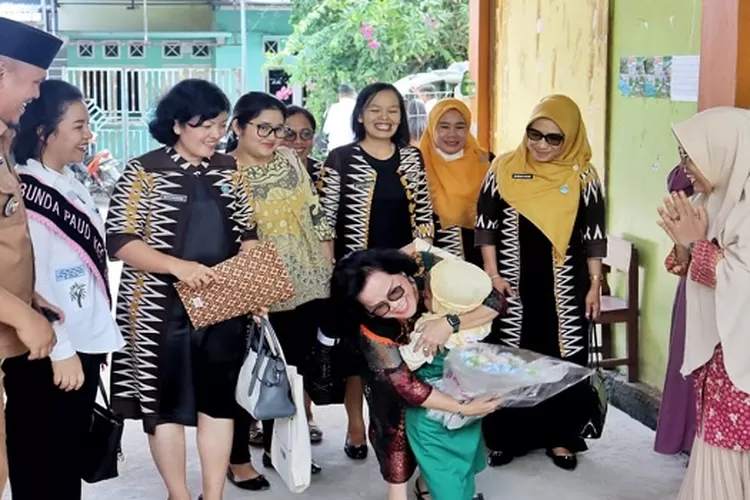 Penuh kasih sayang, Bunda PAUD Ratnawati Radiapoh Hasiholan Sinaga memeluk pasca menerima karangan bunga dari anak TK ABA  (Realitasonline/SS)