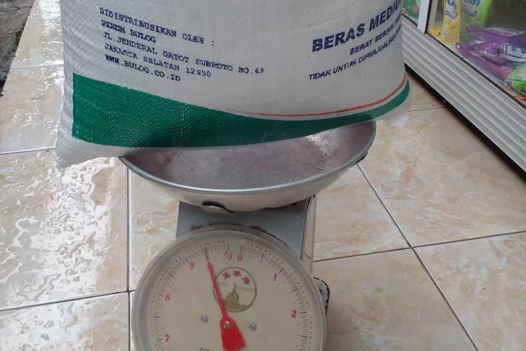 Warga Desa Cinangka menimbang beras yang diterima hanya sekitar 9 kilogram