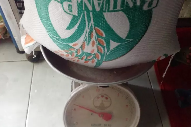 Warga Desa Cinangka menimbang beras yang diterima hanya sekitar 8 kilogram