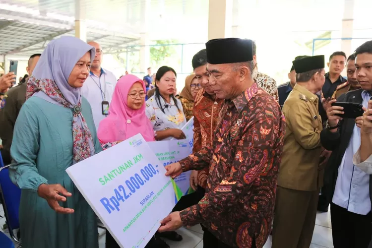 Menko PMK Muhadjir Effendy menyerahkan santunan BPJS Ketenagakerjaan kepada ahli waris di Lampung Utara.