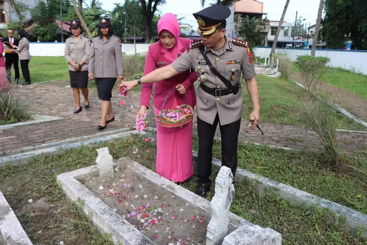 Kapolresta Deli Serdang Kombes Irsan Sinuhaji bersama Ibu menaburkan bunga di sala satu makam