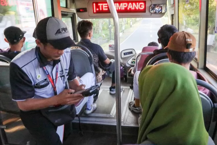 Petugas Trans Jateng sedang melakukan transaksi pembayaran digital bersama penumpang. (Humas Jateng)