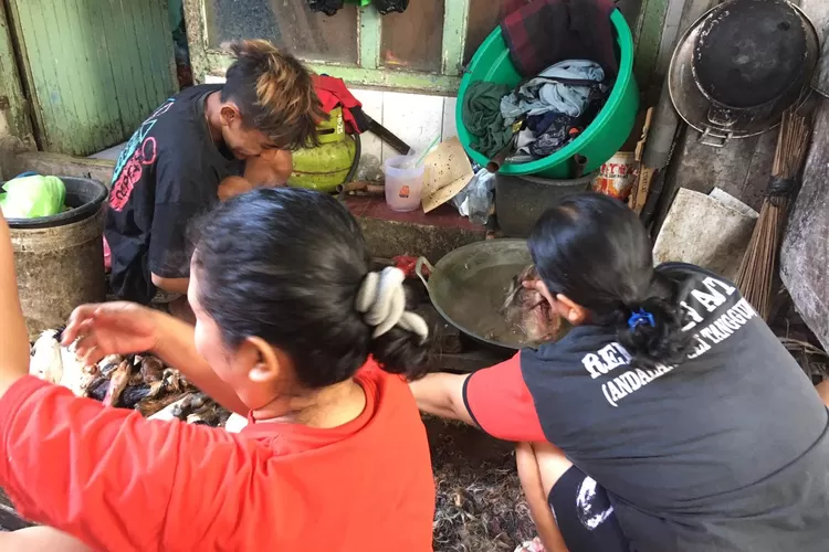 Warga Kampung Bustaman Semarang saat membedah kepala kambing dan sapi dalam tradisi Bengkel Kepala. (Audrian Firhannusa)