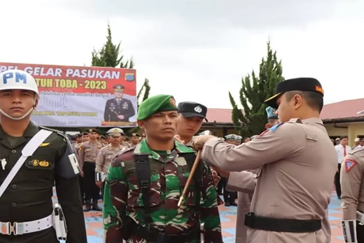 Kapolres Taput Johanson Sianturi sematkan pita tanda Ops Patuh Toba kepada personil TNI AD (Realitasonline.id/MN)