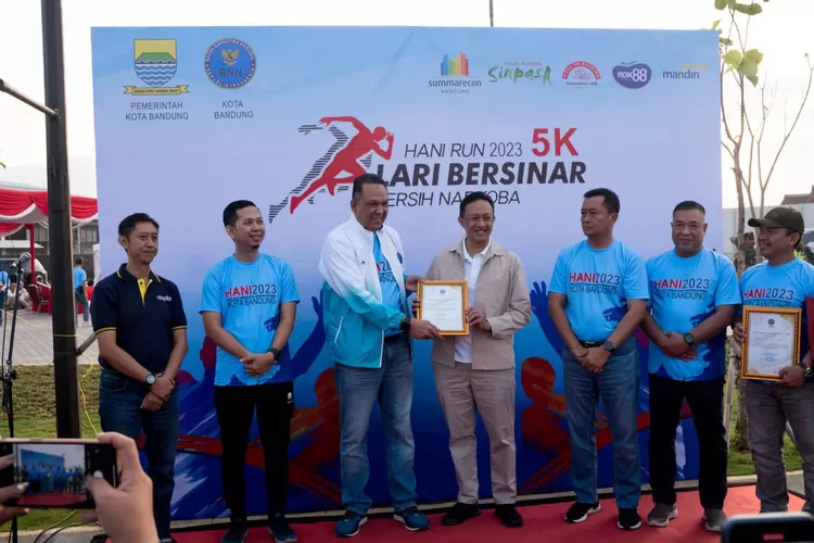Kepala BNN Jawa Barat, Brigjen Pol M. Arief Ramdani memberikan penghargaan kepada Kepala Diskominfo Kota Bandung, Yayan A. Brilyana pada kegiatan HANI Run 2023 Lari Bersinar, di kawasan Summarecon Bandung, kemarin ini.