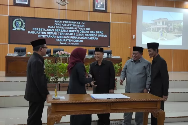 Bupati Demak Eisti'anah dan Ketua DPRD Kabupaten saling berjabat tangan usai penandatangan persetujuan bersama 5 Perda Kabupaten Demak.  (Zaidi)