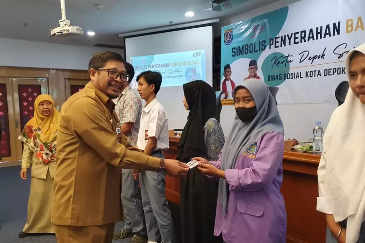 SERAHKAN : Staf Ahli Wali Kota Depok Bidang Politik Hukum dan Pemerintahan, Wijayanto saat menyerahkan KDS pendidikan di Aula Kantor Bank BJB, Senin (10/7). ISTIMEWA