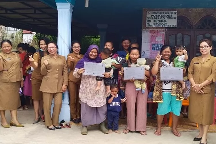 Kapus Sitadatada Bungani Sirait diabadikan usai menyerahkan sertifikat imunisasi kepada ibu balita dua tahun di Desa Hutaraja Kecamatan Sipoholon  (Realitasonline.id/Alpon Situmorang)