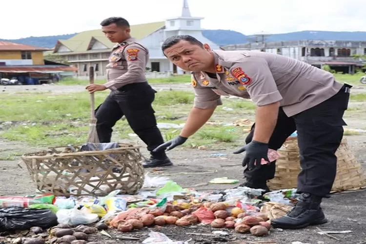 Kapolres Taput Johanson Sianturi turun memungut sampah dilingkungan pajak Tarutung (Realitasonline.id/MN)