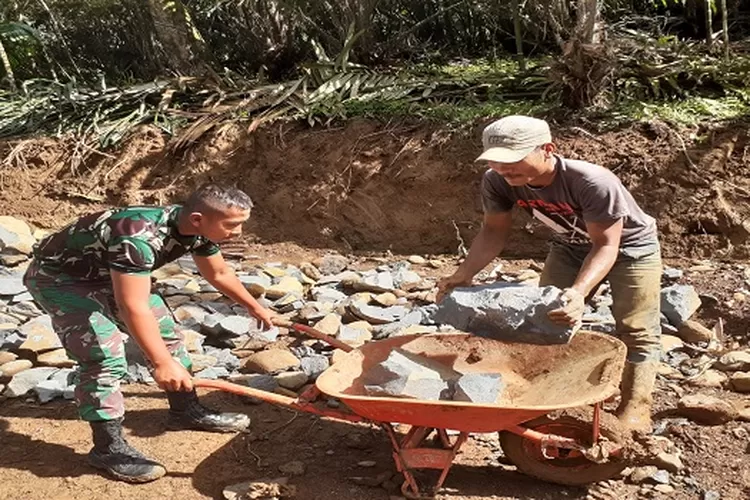 Prajurit TNI yang tergabung dalam Satgas TMMD 117 Kodim 0212/Tapsel bersama warga bergotong royong menyusun batu kali untuk pengerasan badan jalan TMMD  (Realitasonline.id/Riswandy)