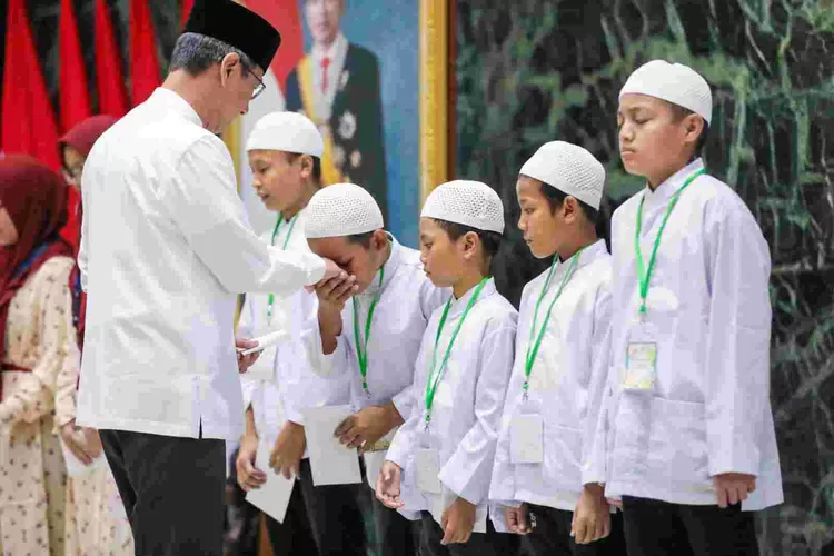 Pj Gubernur DKI Jakarta Heru Budi  Hartono menyerahkan santunan anak yatim  dalam rangka peringatan Tahun Baru Islam,( 1 Muharam) di Balai Agung, DKI Jakarta. ( ()